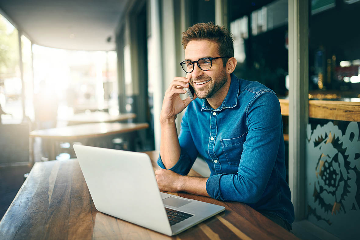 A man with a laptop computer talks on his phone